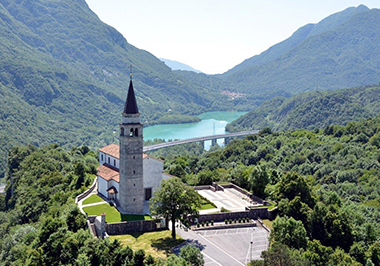 La pieve di Santo Stefano a Cesclans; sullo sfondo, il lago di Cavazzo
